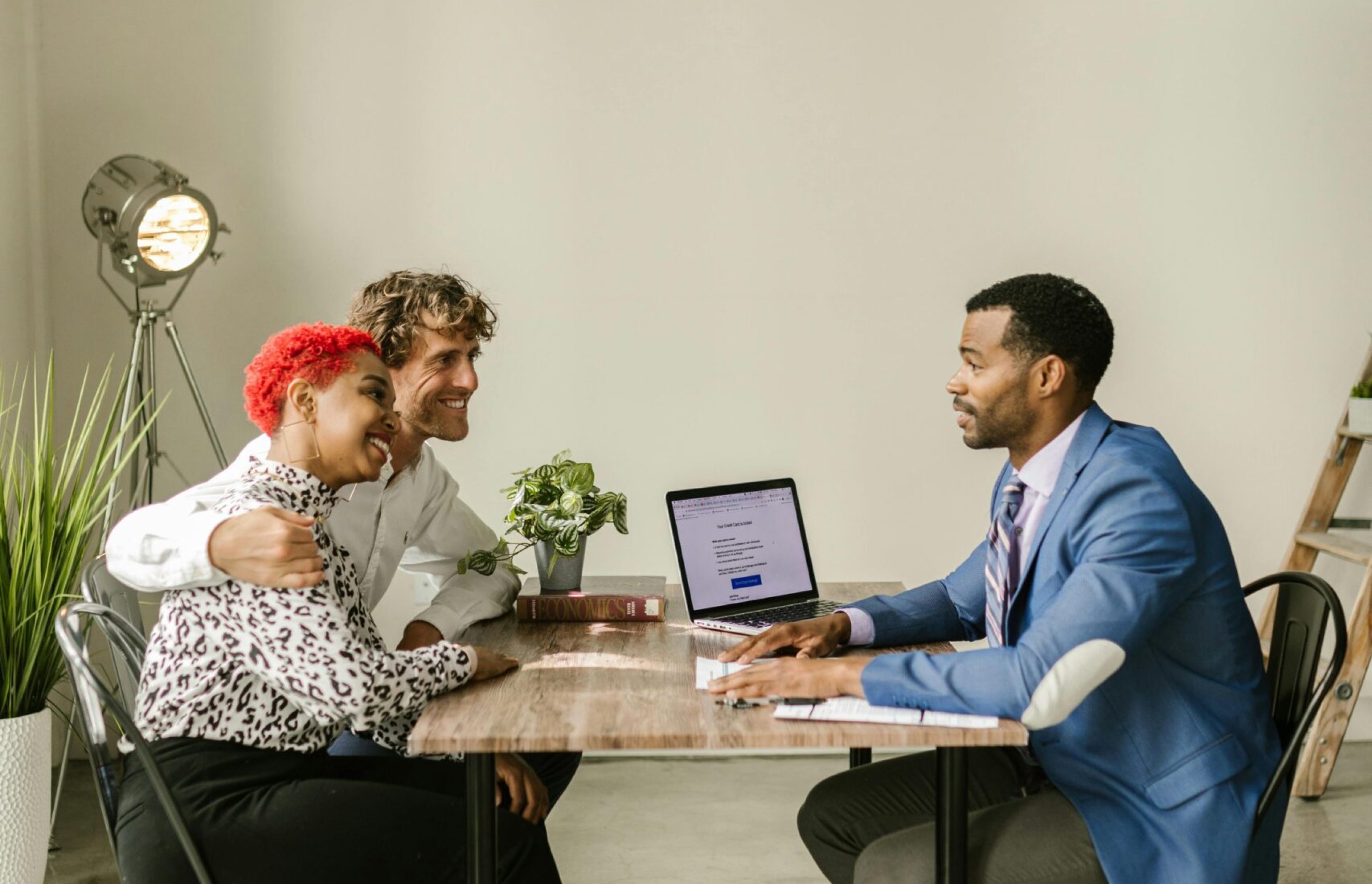 A professional financial advisor discusses options with a couple in a modern office setting.